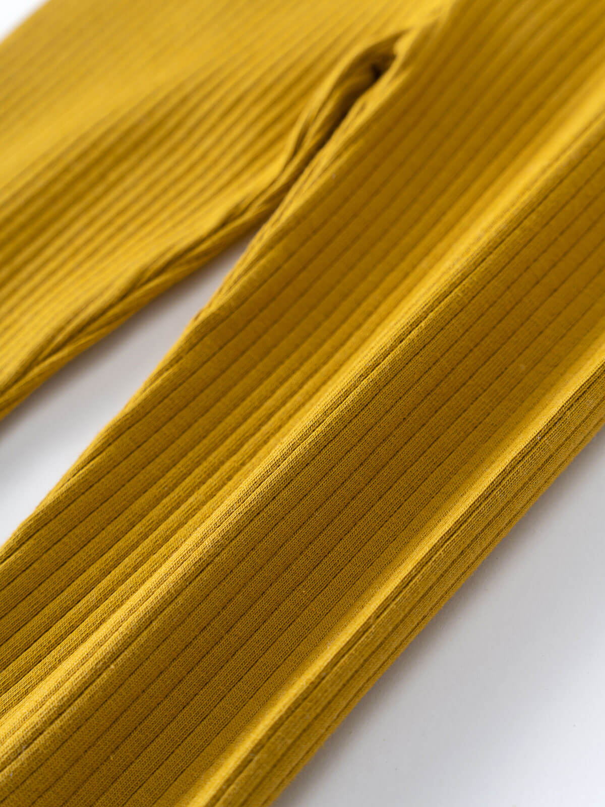 Close-up of golden yellow ribbed fabric leggings showing texture and pleats Baby Ribbed Leggings - Golden Pear Baby boy