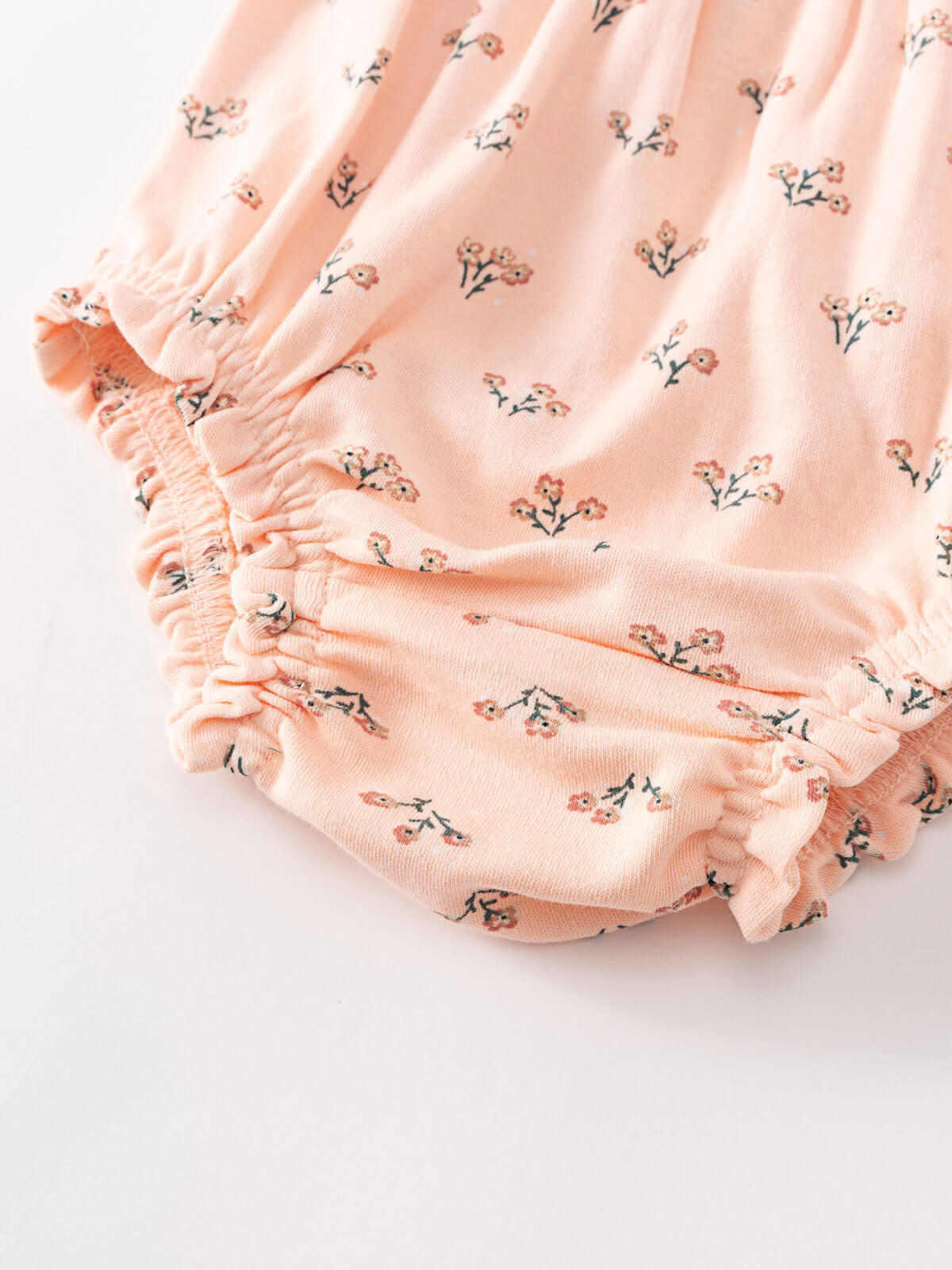 Close-up of peach fabric with small floral print and elastic gathered edges Printed Bloomers - Wildflower Bouquet Pink Baby girl