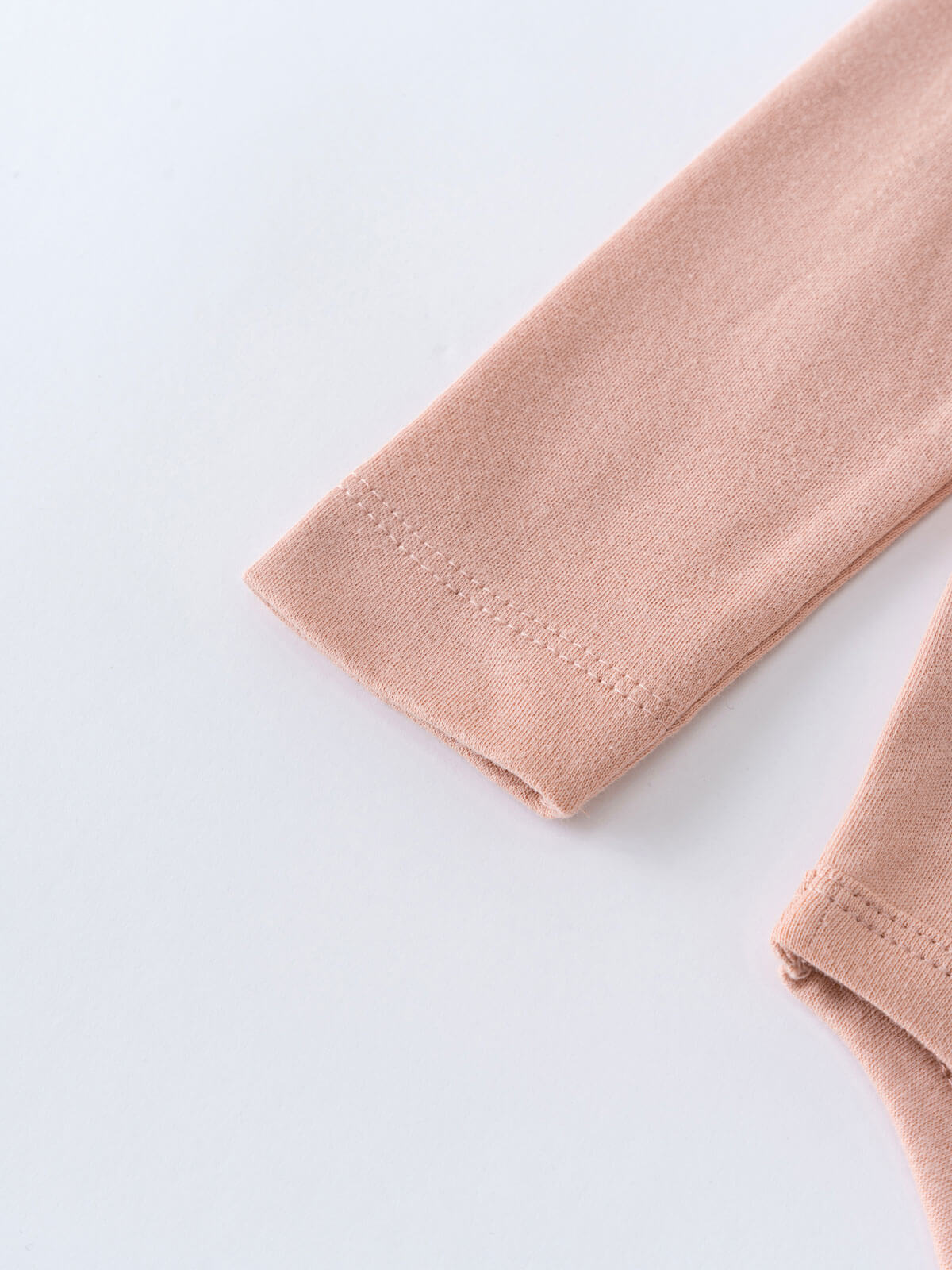 Close-up of blush pink knitted fabric sleeves with ribbed cuffs Ruffle Long Sleeve Bodysuit - Blush Baby girl