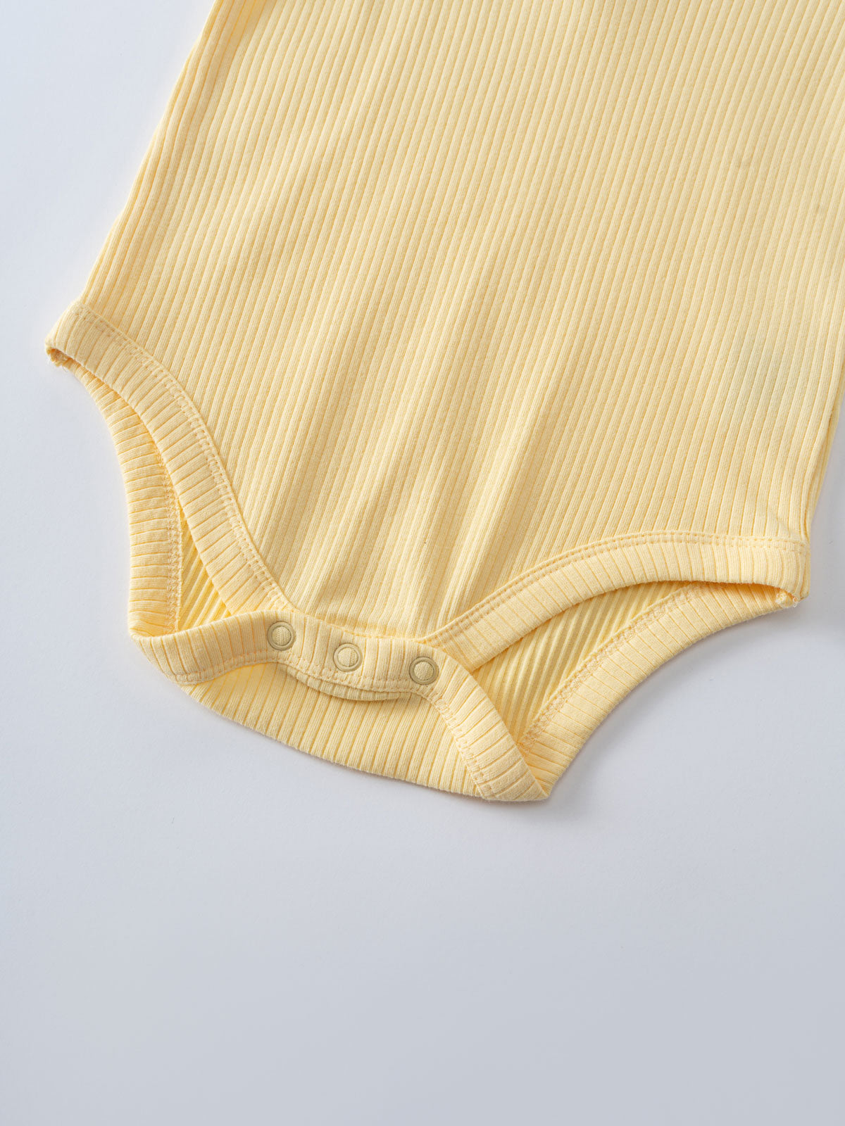 Close-up of a yellow ribbed bodysuit with snap closures at the bottom Avery Henley Bodysuit - Sun Soaked Baby girl