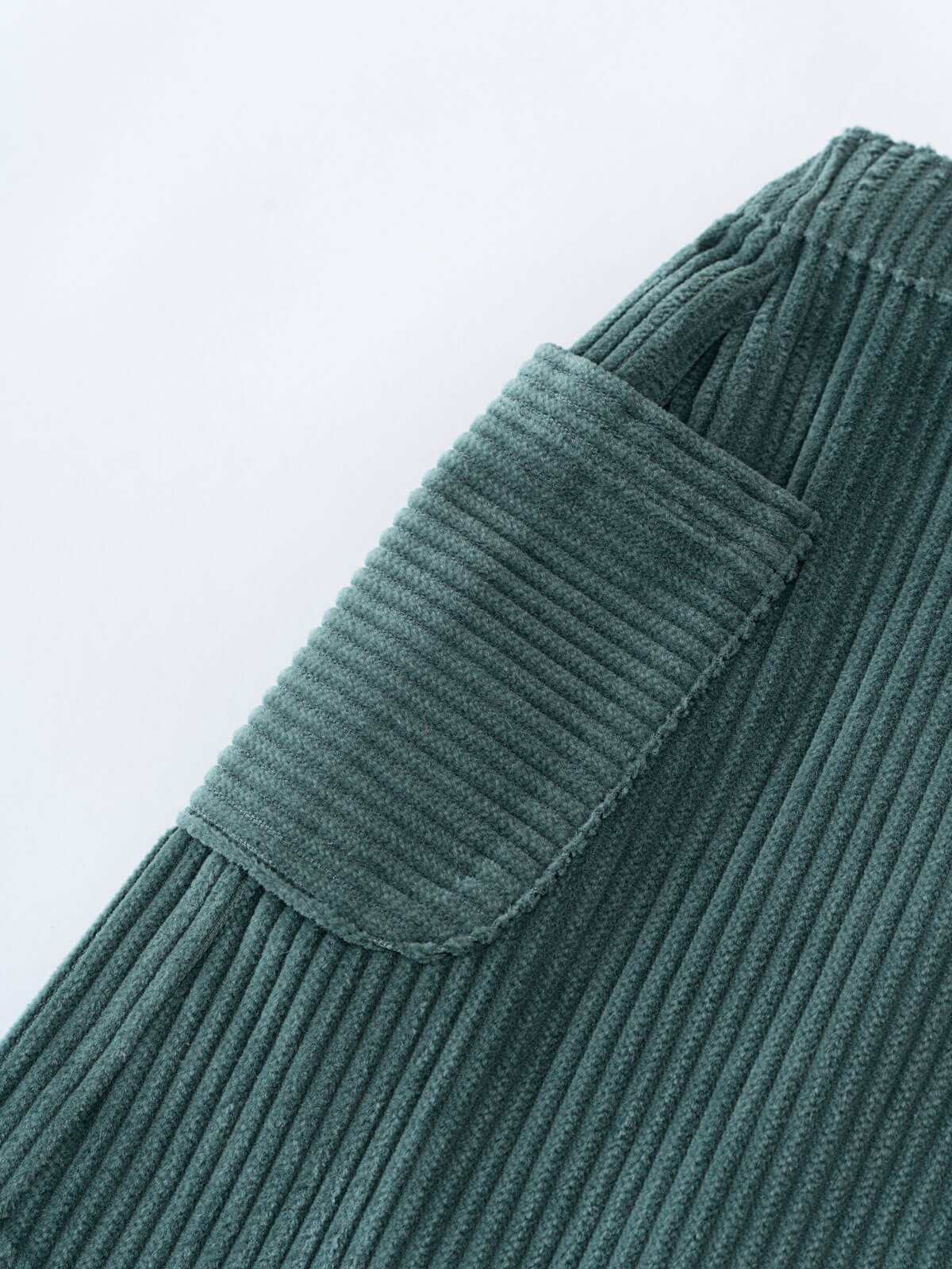 Close-up of a green corduroy skirt with a pocket on a white background