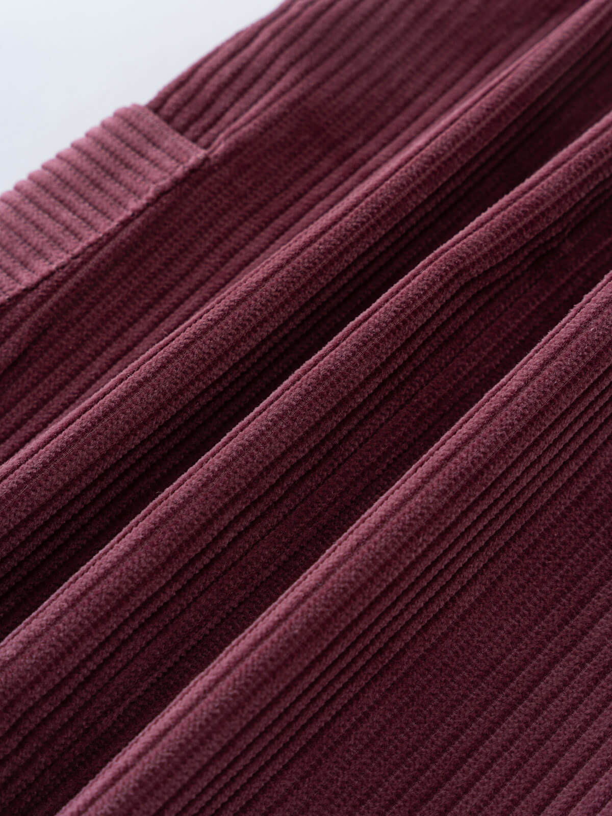 Close-up of a plum corduroy pinafore dress in a deep purple color. Corduroy Pinafore Dress - Plum Jam Girls