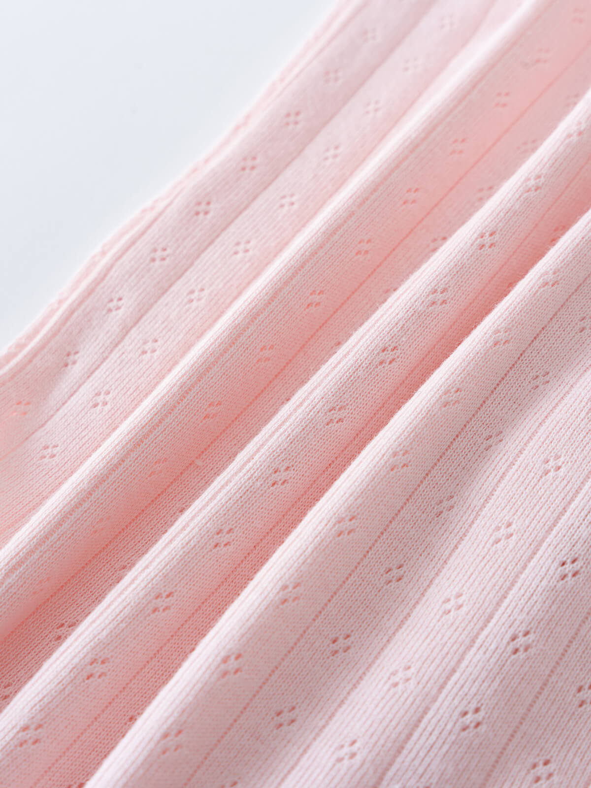 Close-up of pink ribbed fabric with eyelet detail showing texture and folds Elise Long Sleeve One Piece - Candy Floss Baby girl
