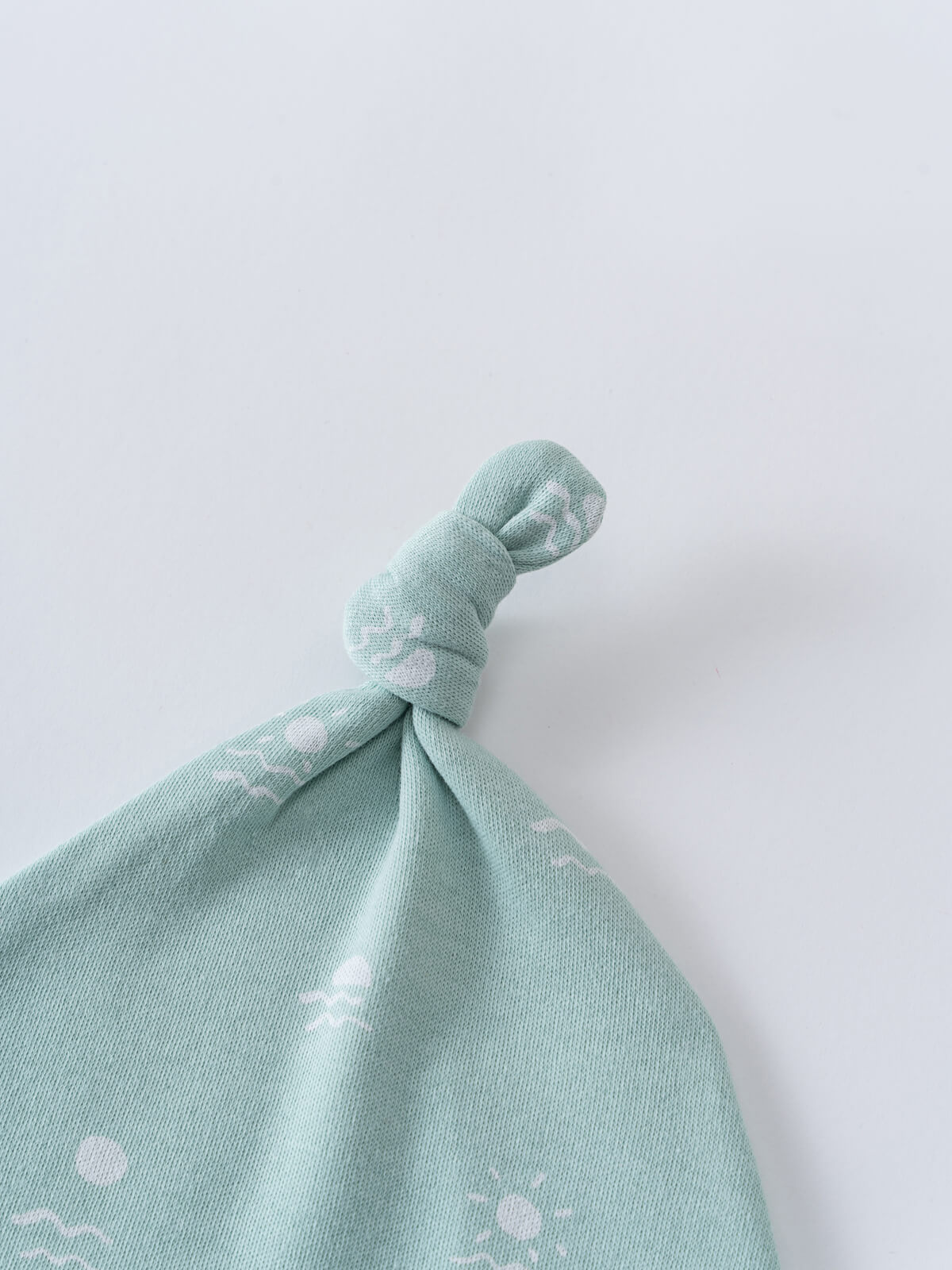 Close-up of a knotted baby hat in mint green with white pattern Ezra Knot Hat - Summer Time Baby boy