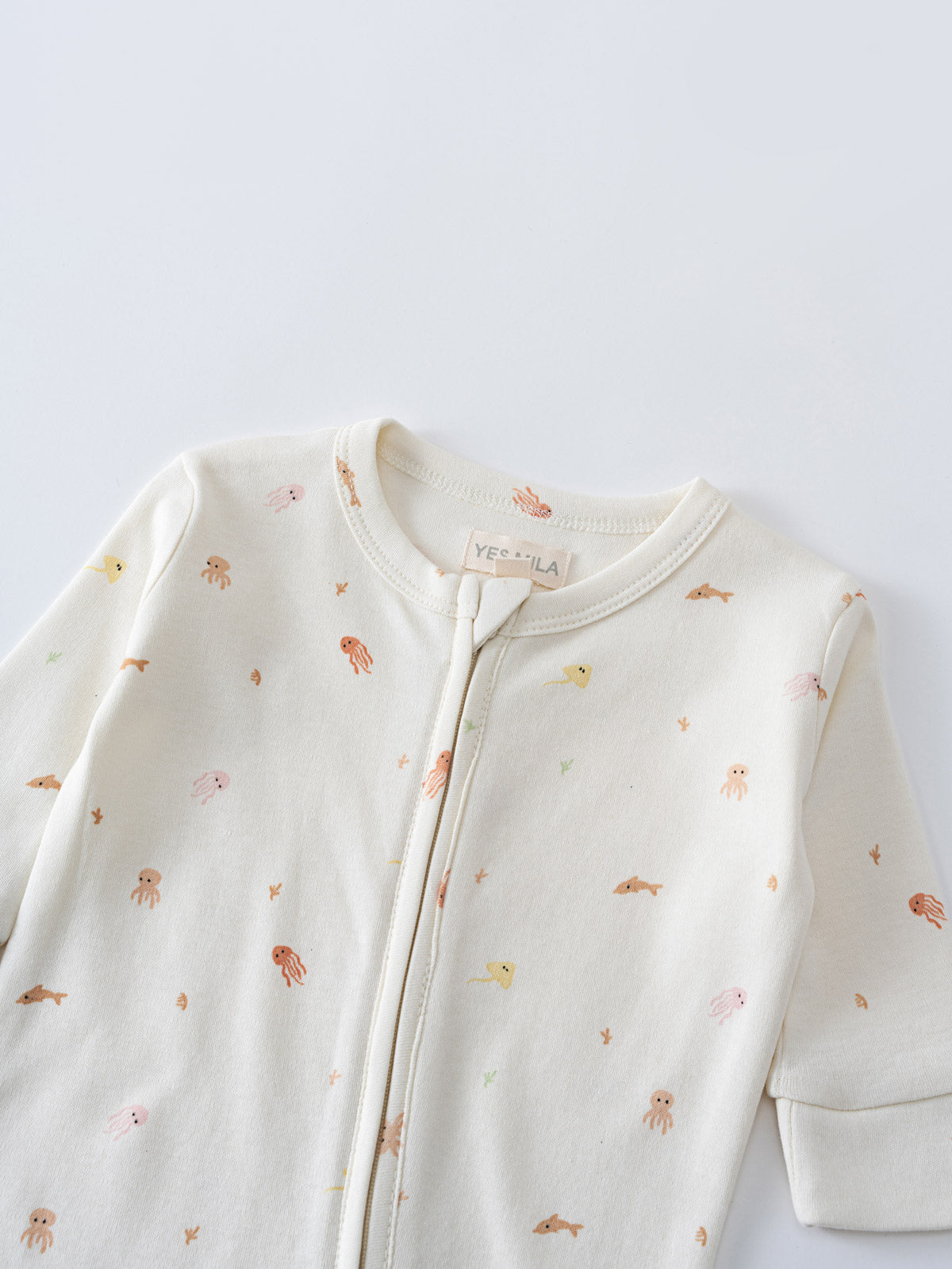 Close-up of a cream zippered onesie with small ocean animal print Ivy Long Sleeve One Piece - Ocean Buddies Baby girl