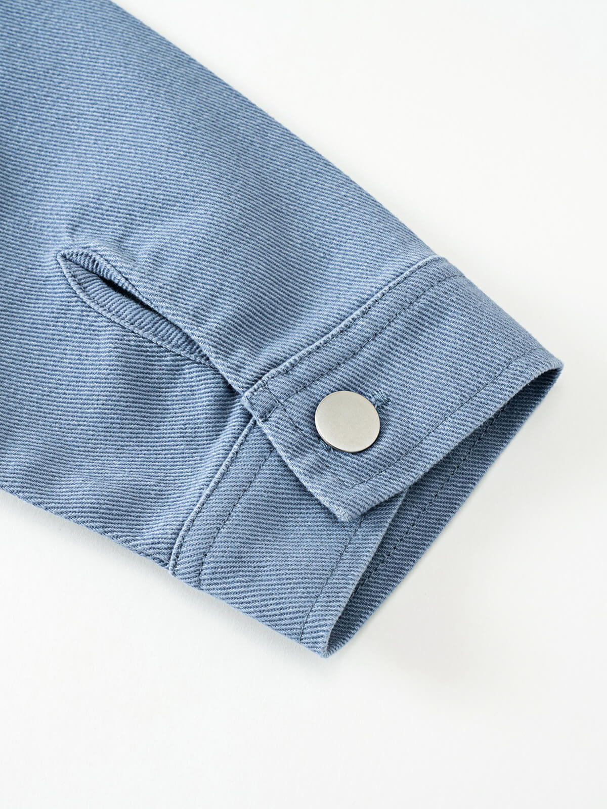 Close-up of a light blue textured fabric sleeve cuff with silver button James Jacket - Sky Blue Boys