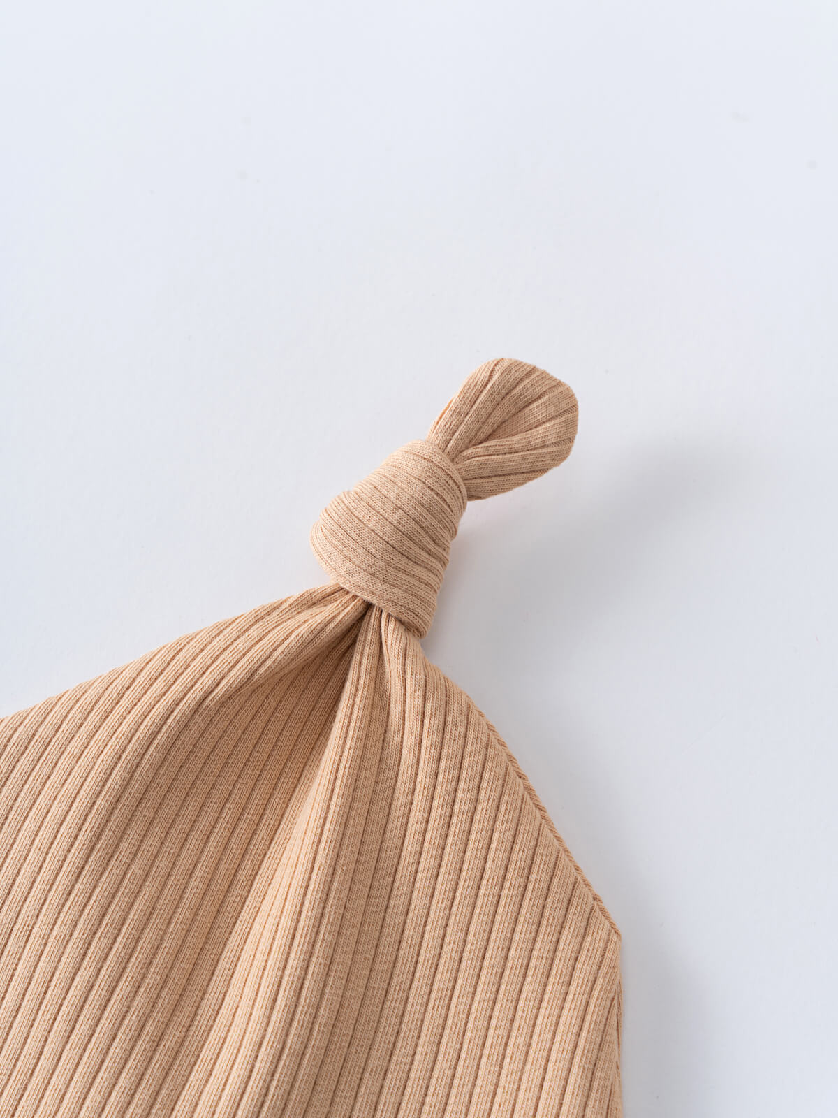 Close-up of a beige ribbed knit fabric with a knotted top Levi Knot Hat - Sand Baby boy