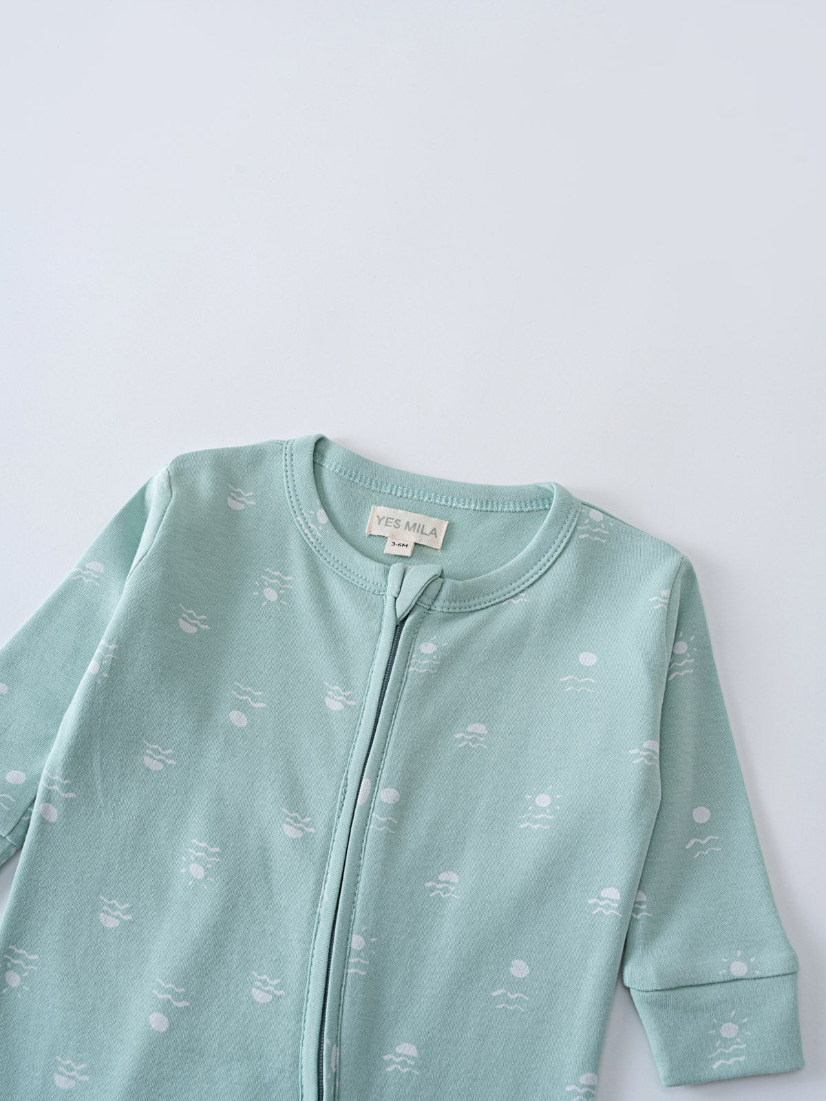 Close-up of a light blue zippered onesie with small printed pattern Miles Long Sleeve One Piece - Summer Time Baby boy