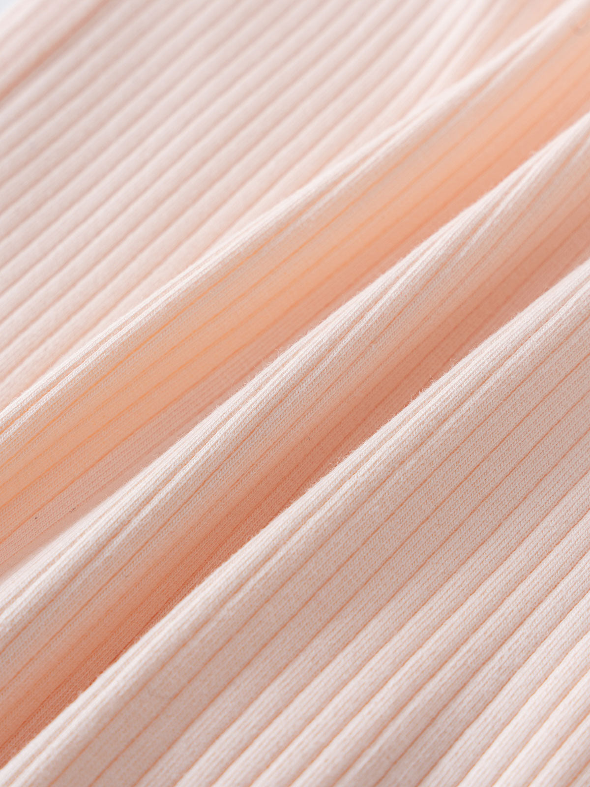 Close-up of ribbed fabric in a soft peachy pink color Nova Long Sleeve One Piece - Shell Pink Baby girl