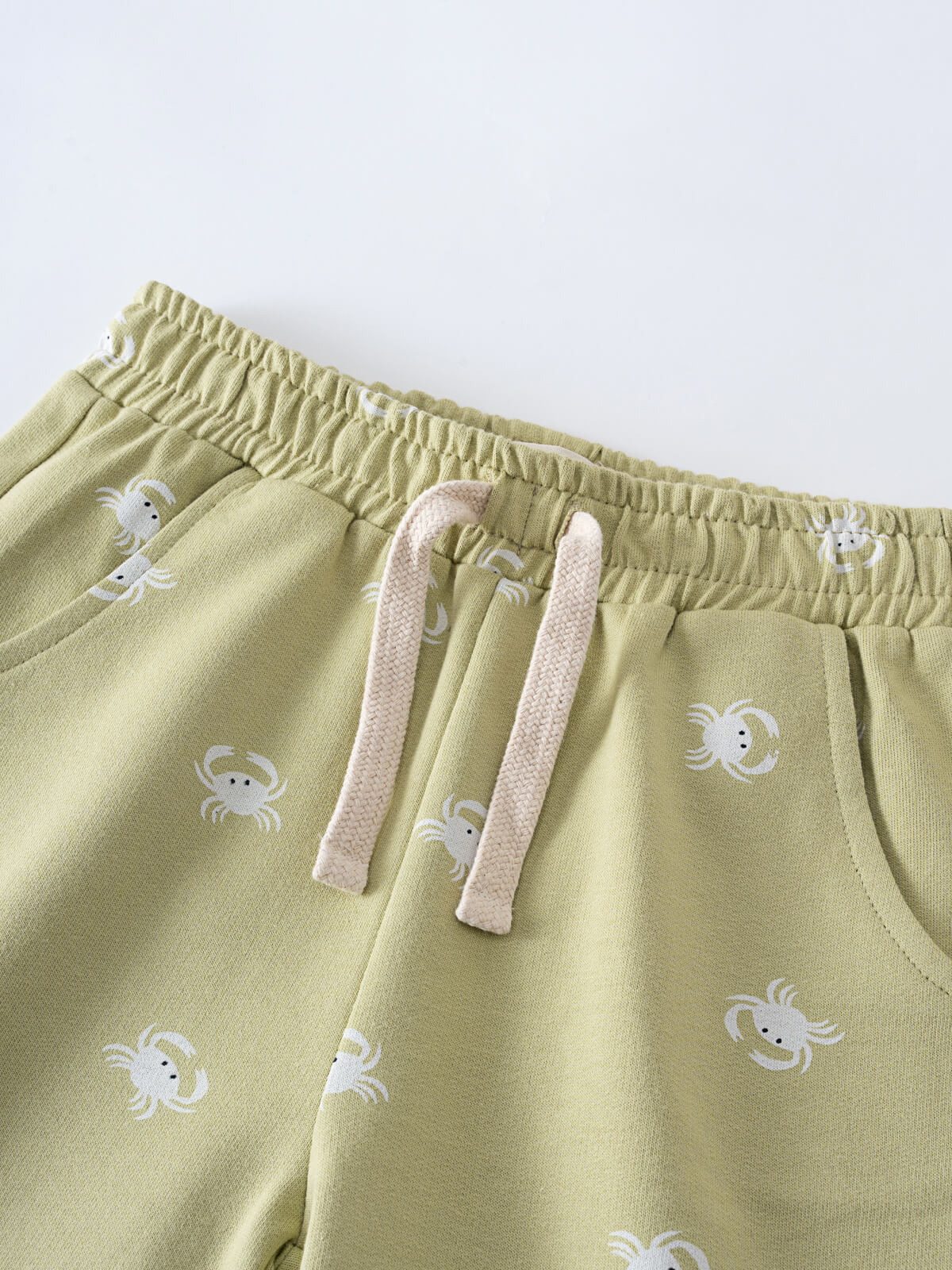 Close-up of sage green shorts with white crab print and drawstring waistband Remi Shorts - Crabby Boys