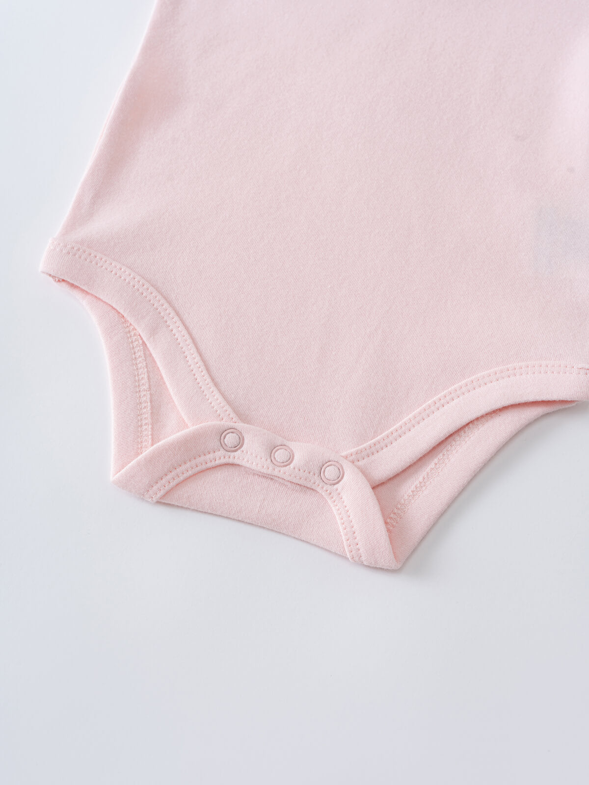 Close-up of a pale pink baby bodysuit showing snap button closure ruffle Short Sleeve Bodysuit - Candy Floss Baby girl