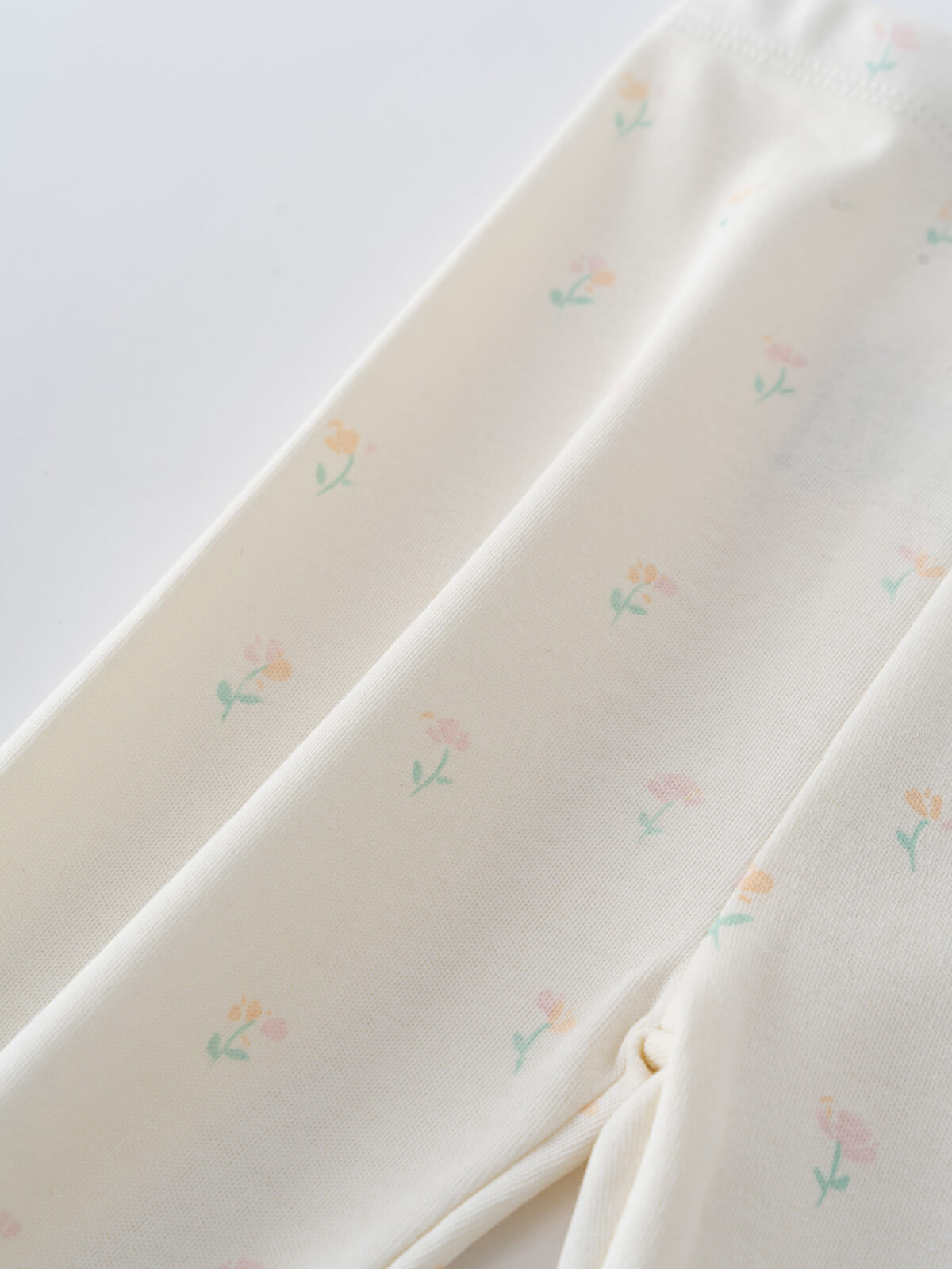 Close-up of cream fabric with small pastel floral print pattern Stella Leggings - Spring Bloom Baby girl