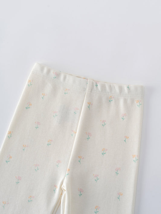 Close-up of cream-colored baby leggings with small pastel floral print Stella Leggings - Spring Bloom Baby girl