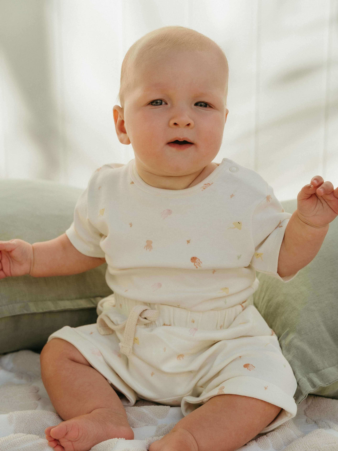 Baby wearing an Ocean Buddies bodysuit and matching shorts by Yes Mila.
