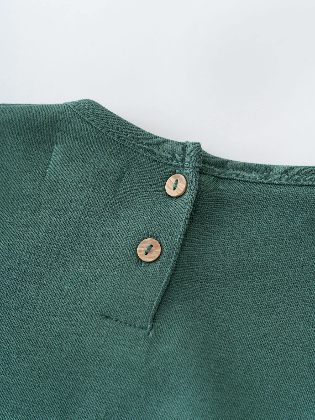 Close-up of green fabric with two buttons near the neckline Baby Long Sleeve Jersey Dress - Meadow Friends Baby girl