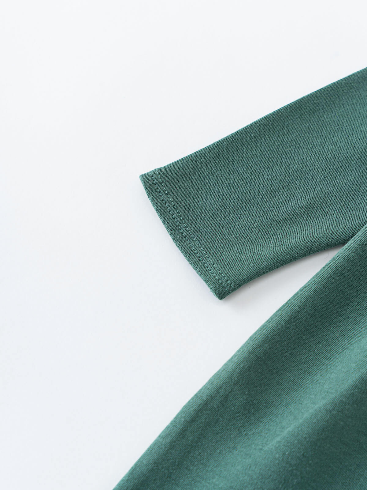Close-up of teal green fabric sleeve with visible stitching detail Baby Long Sleeve Jersey Dress - Meadow Friends Baby girl