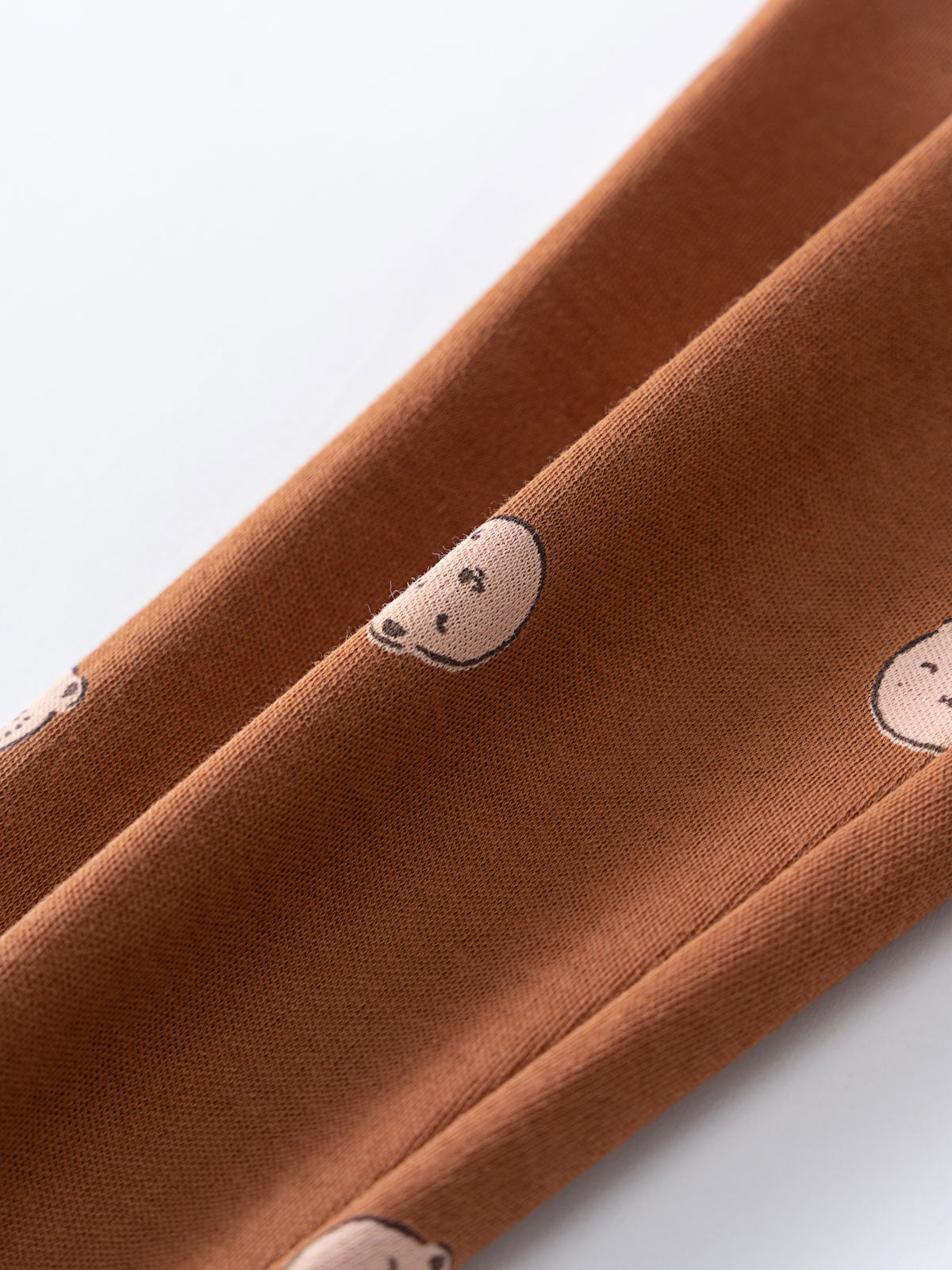 Close-up of brown fabric with small embroidered bear faces Baby Printed Leggings - Cosy Bear Russet Baby boy