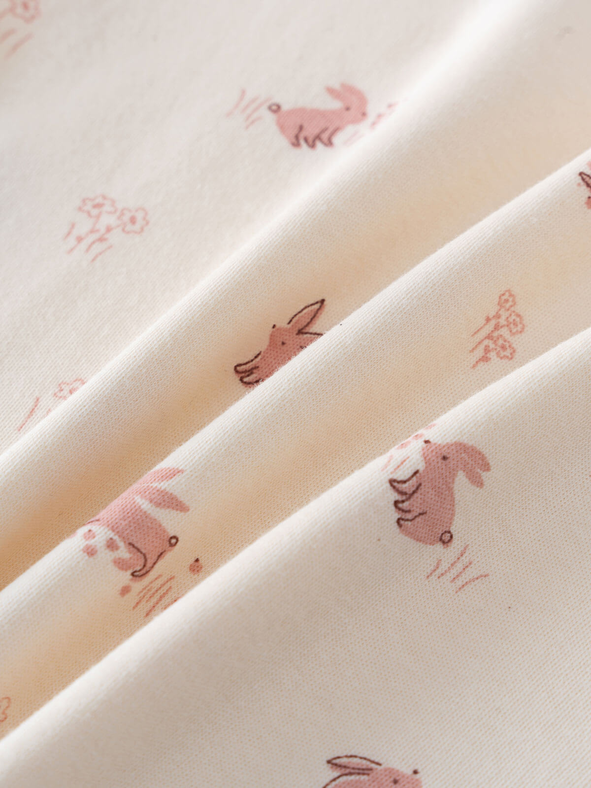 Close-up of cream fabric with pink animal prints including rabbits and dinosaurs Baby Printed Short Sleeve Tee - Meadow Friends Ecru Baby girl