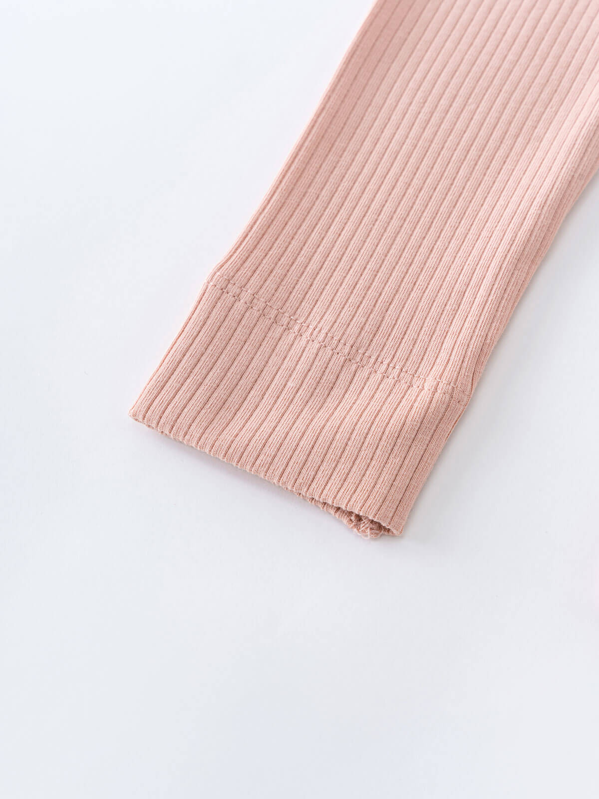 Close-up of pink ribbed fabric legging leg on white surface Baby Ribbed Leggings - Blush Baby girl