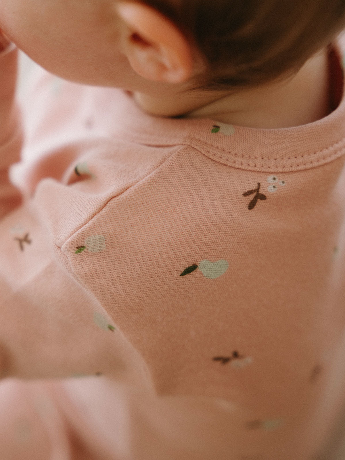 Child wearing pink onesie with small fruit and flower pattern print Printed Long Sleeve One Piece - Autumn Harvest Rosehip Baby girl