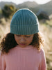 Child wearing teal ribbed beanie and pink sweater outdoors looking down Ribbed Beanie - Balsam Boys