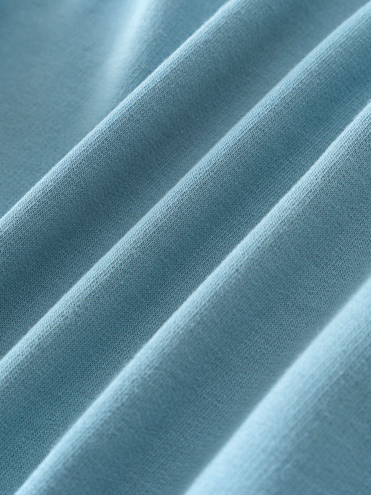 Close-up of light blue fabric with soft folds and visible texture Feature Print Hoodie - Stay Wild Boys