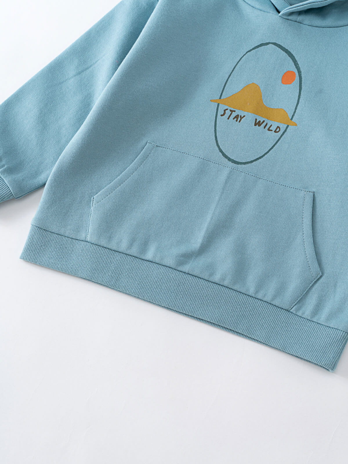 Close-up of light blue hoodie with mountain graphic and front pocket Feature Print Hoodie - Stay Wild Boys