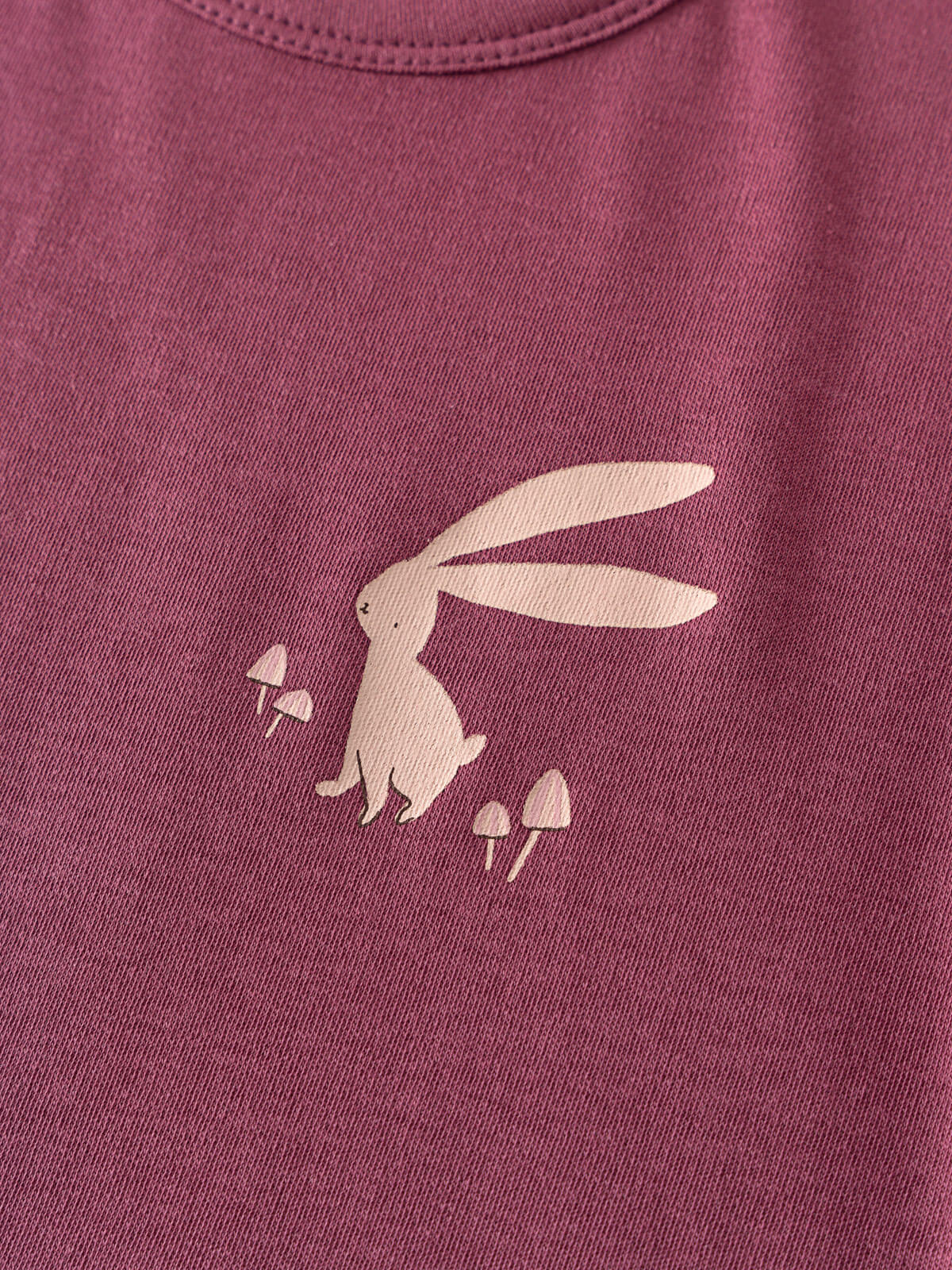 Close-up of pink fabric with a light-colored bunny and mushroom print Feature Print Short Sleeve Tee - Forest Gathering Girls