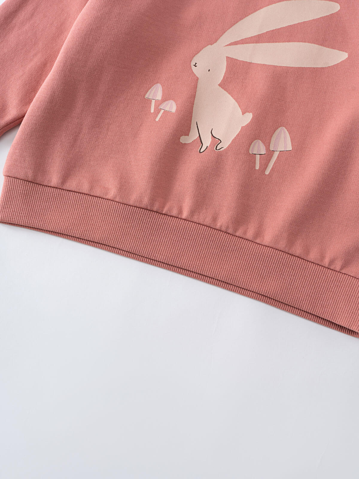 Close-up of pink sweatshirt hem with white rabbit and mushroom print Feature Print Sweatshirt - Forest Gathering Girls