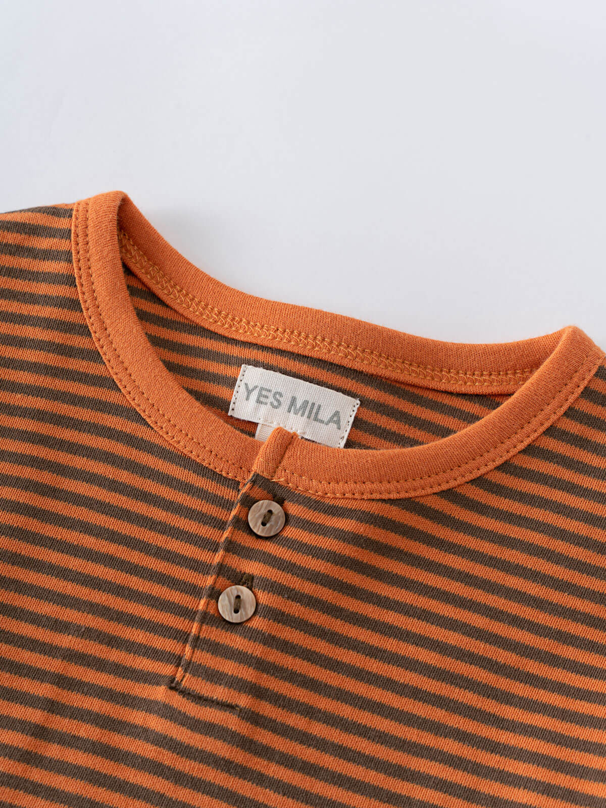 Close-up of orange and brown striped shirt with button placket Henley Long Sleeve Tee - Pumpkin Boys
