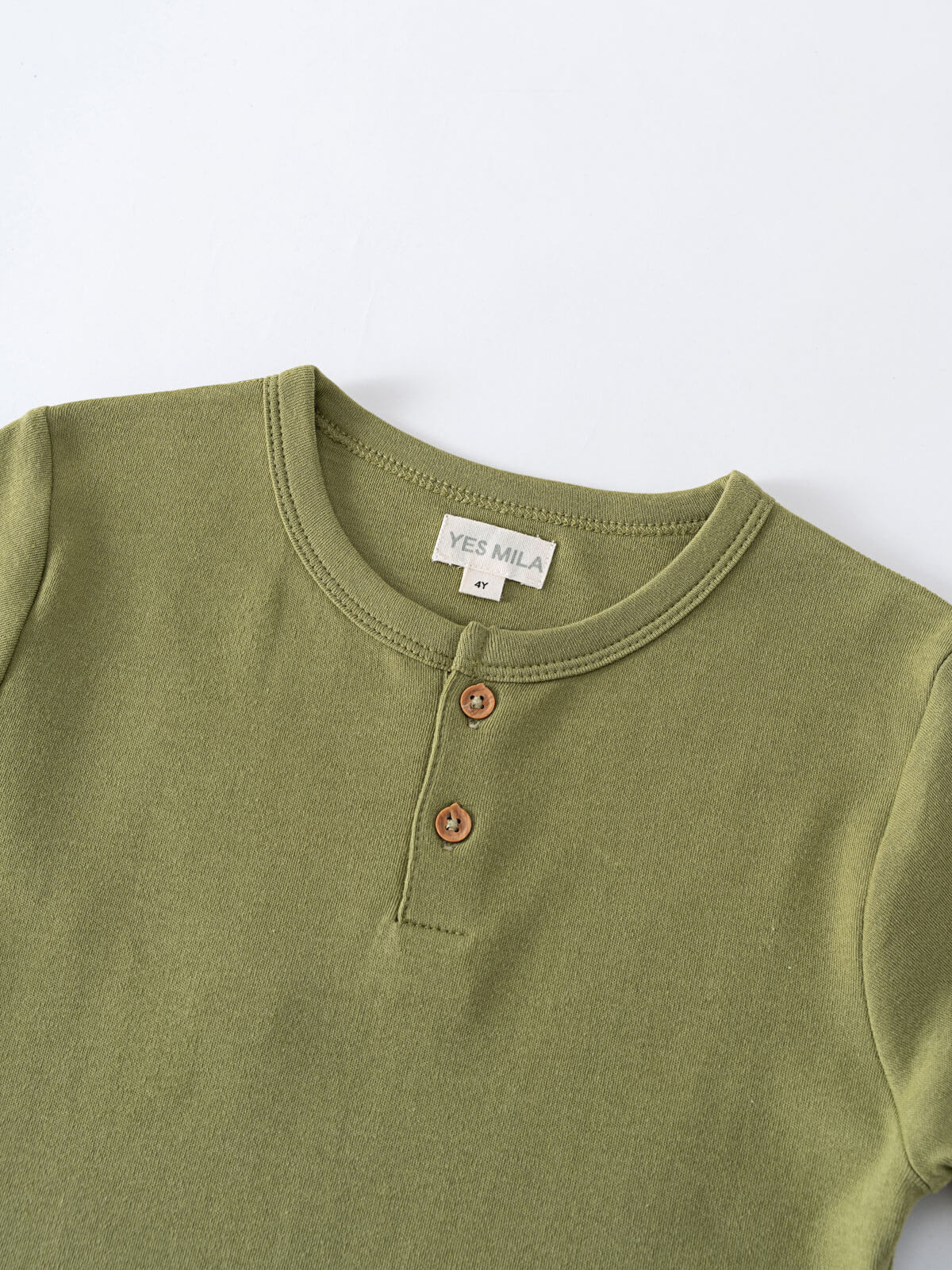 Close-up of an olive green henley shirt with two brown buttons Henley Short Sleeve Tee - Moss Boys