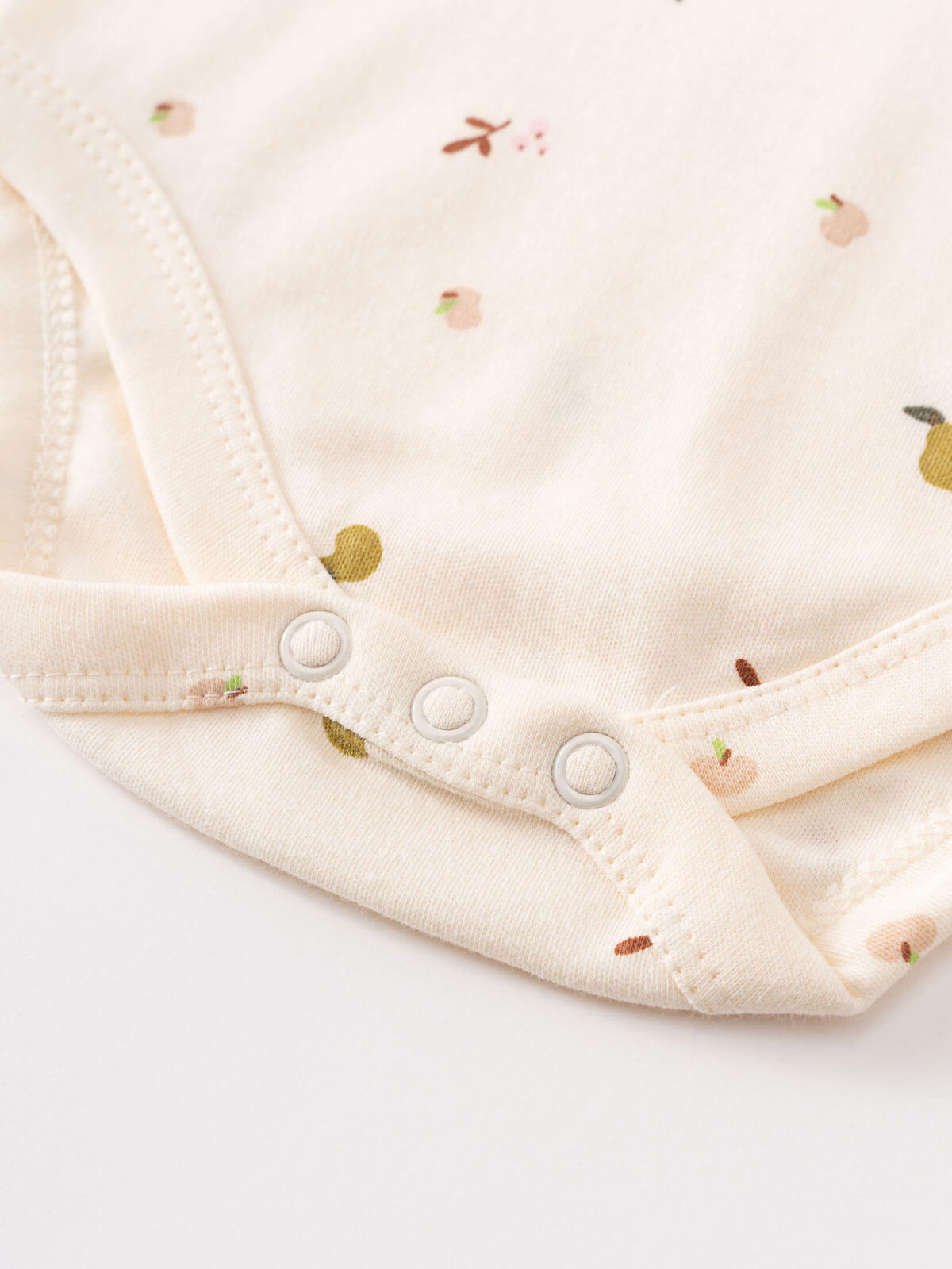 Close-up of cream-colored baby bodysuit with snap buttons and fruit embroidery Henley Short Sleeve Bodysuit - Autumn Harvest Ecru Baby girl