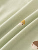 Close-up of sage green fabric with small embroidered acorn character details Henley Short Sleeve Bodysuit - Little Acorn Sage Baby boy
