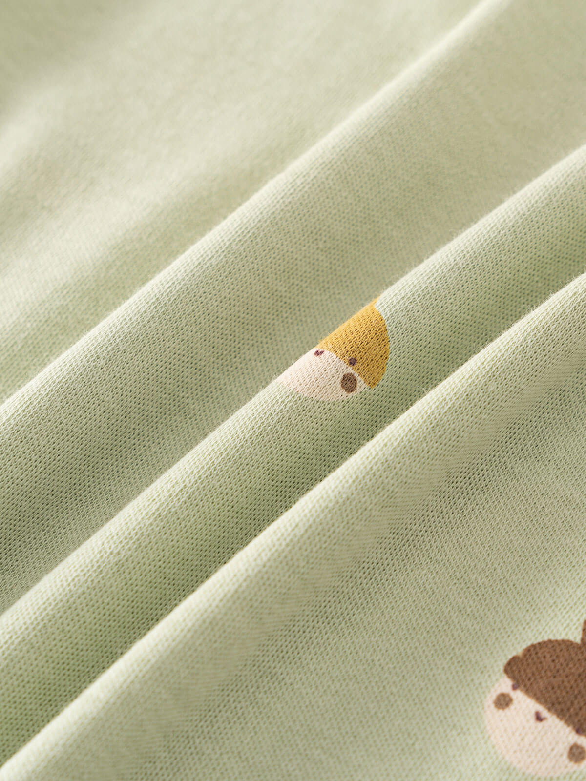Close-up of sage green fabric with small embroidered acorn character details Henley Short Sleeve Bodysuit - Little Acorn Sage Baby boy