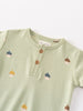 Close-up of a sage green baby bodysuit with acorn face pattern and button placket Henley Short Sleeve Bodysuit - Little Acorn Sage Baby boy