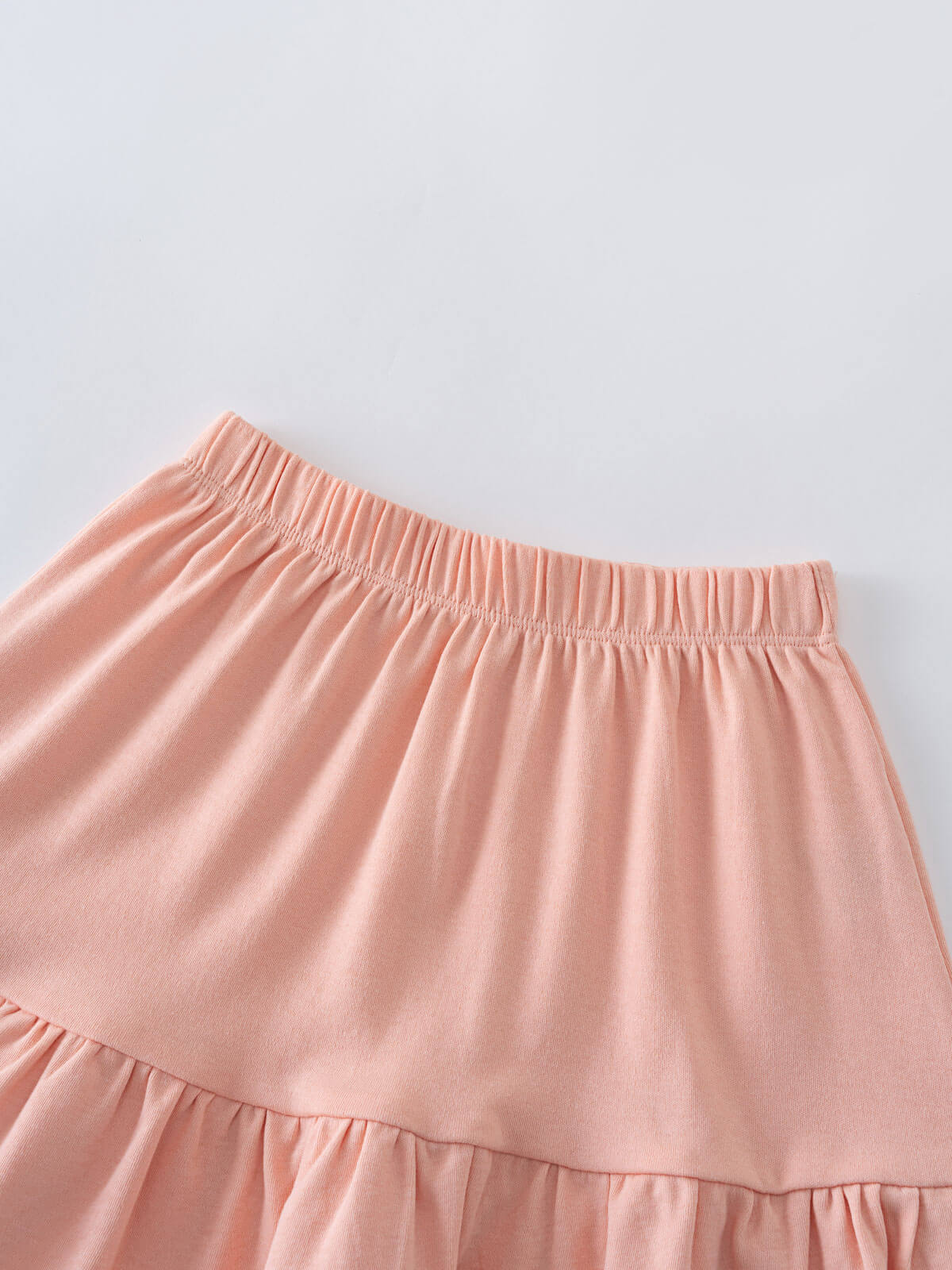 Close-up of a pink tiered skirt with elastic waistband on white surface Jersey Skirt - Mallow Girls