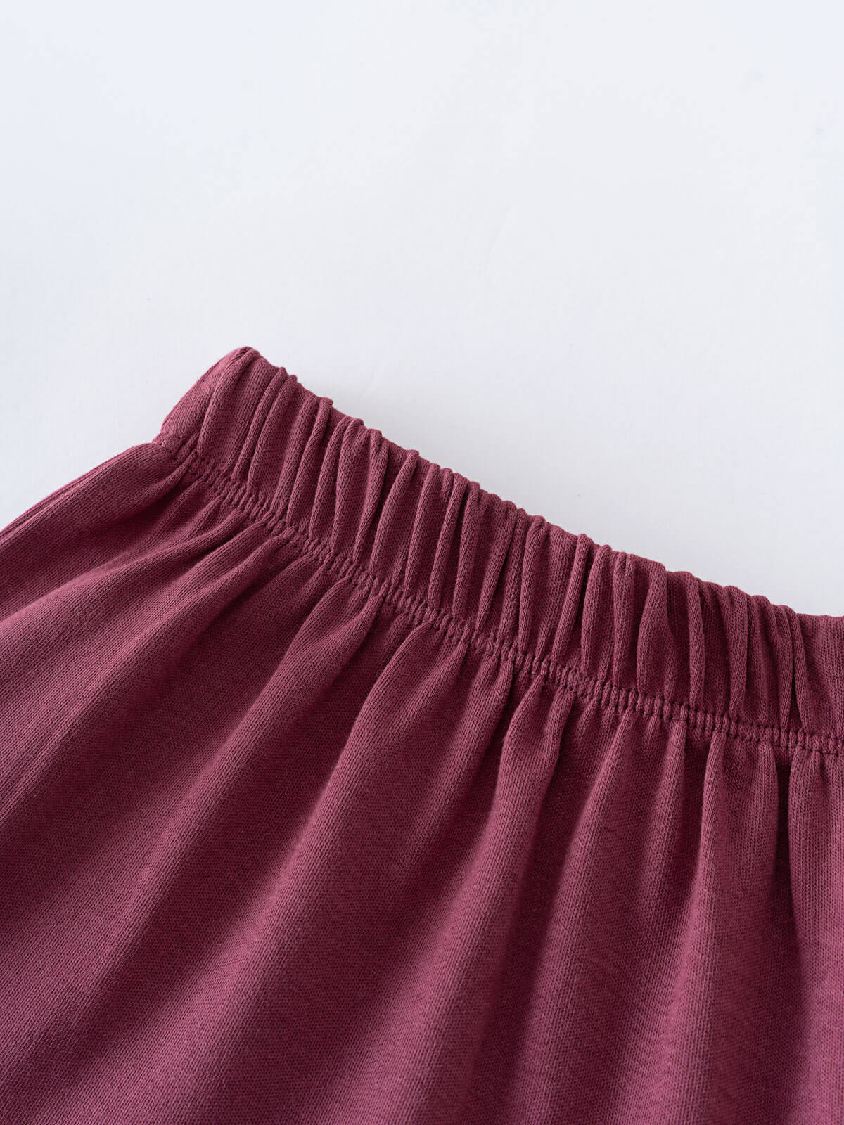 Close-up of burgundy fabric with gathered elastic waistband detail Jersey Skirt - Plum Jam Girls