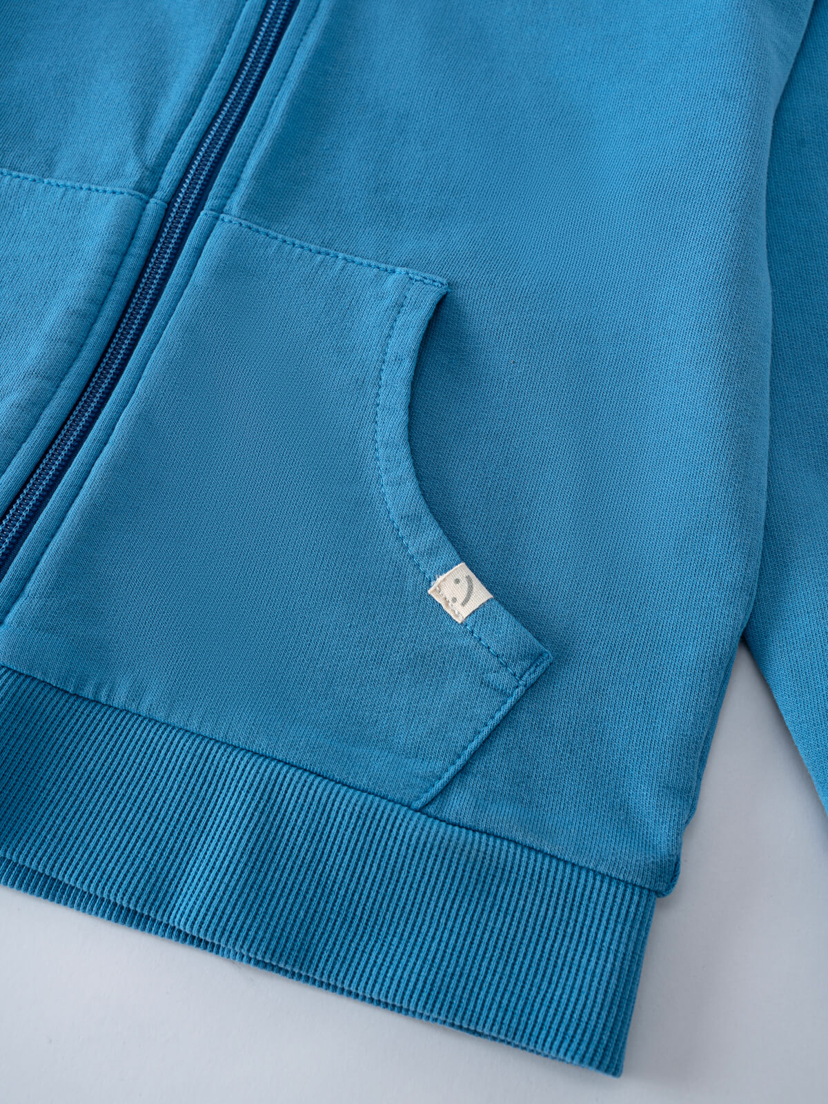 Close-up of a blue hoodie pocket with zipper and ribbed hem detail Lightweight Zip Hoodie - Marine Boys