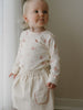 Toddler in a patterned long sleeve top and corduroy skirt standing indoors Long Sleeve Bodysuit - Meadow Friends Ecru Baby girl
