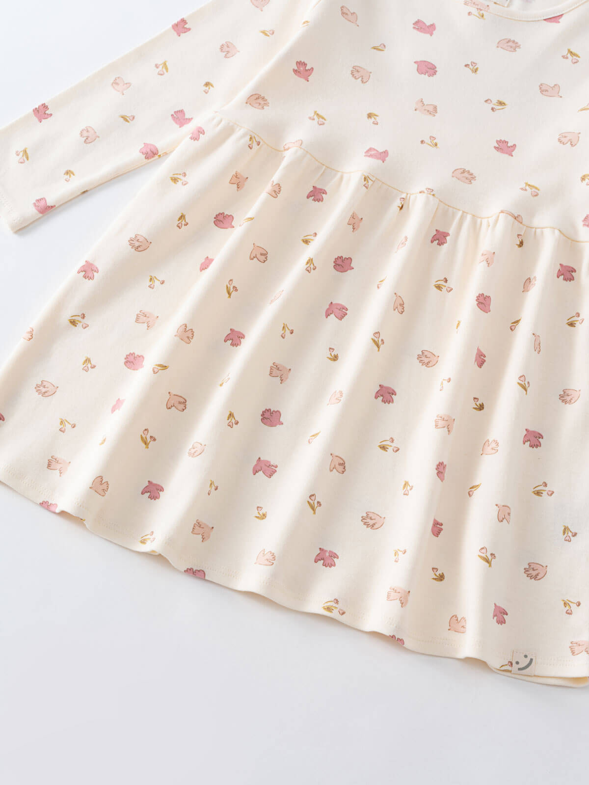 Close-up of cream fabric with small pink and peach floral print Long Sleeve Jersey Dress - Bird And Blossom Ecru Girls