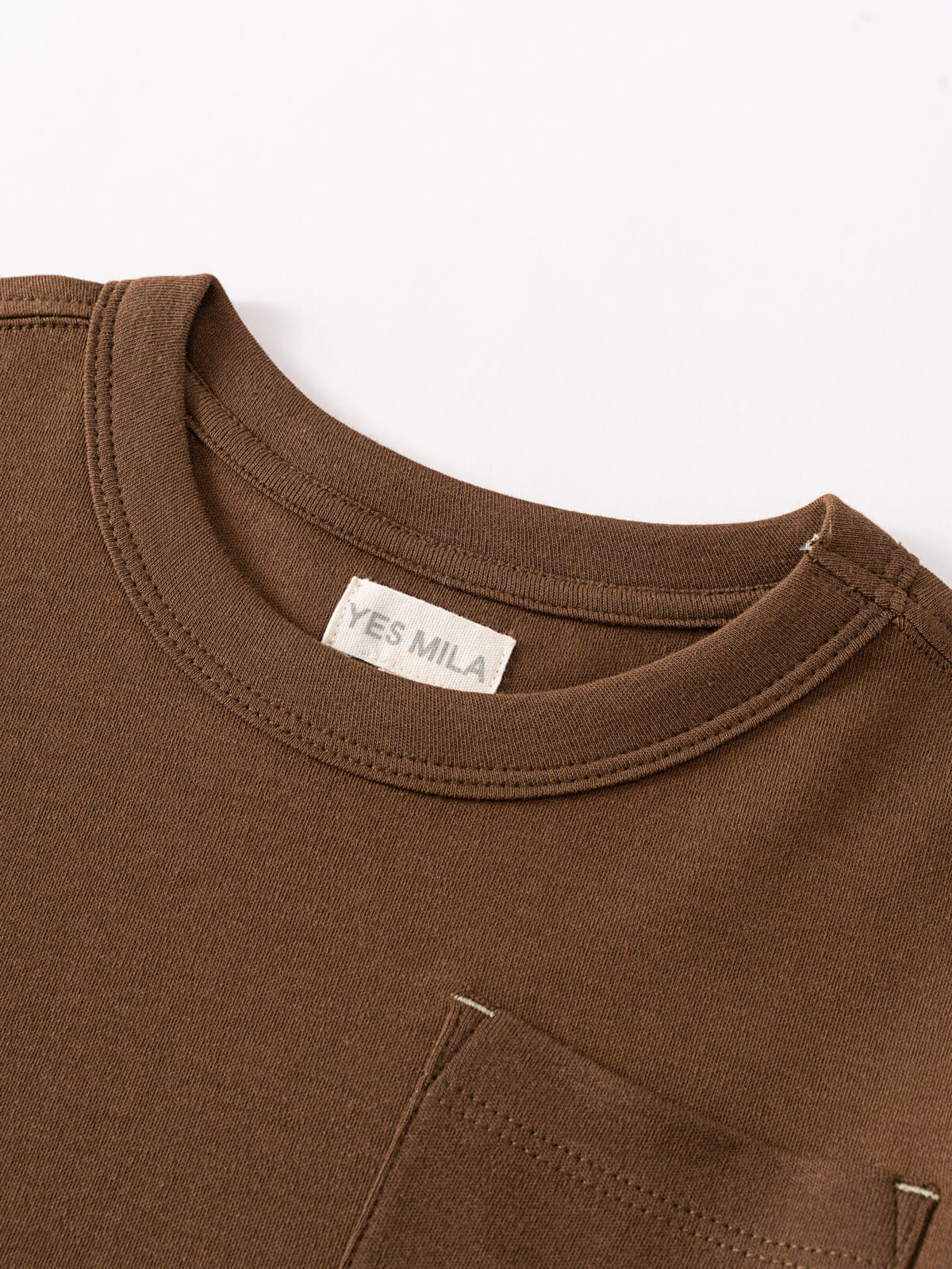 Close-up of brown long sleeve shirt collar with white label and chest pocket Long Sleeve Tee - Spruce Boys