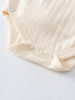 Close-up of cream-colored ribbed baby bodysuit with snap buttons and pointelle detail Pointelle Crossover Bodysuit - Ecru Baby boy