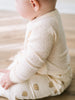 Baby wearing cream ribbed bodysuit with eyelet detail and cookie print shorts Pointelle Crossover Bodysuit - Ecru Baby boy