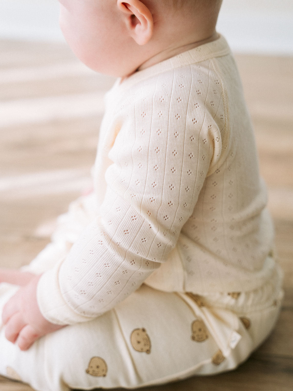 Baby wearing cream ribbed bodysuit with eyelet detail and cookie print shorts Pointelle Crossover Bodysuit - Ecru Baby boy