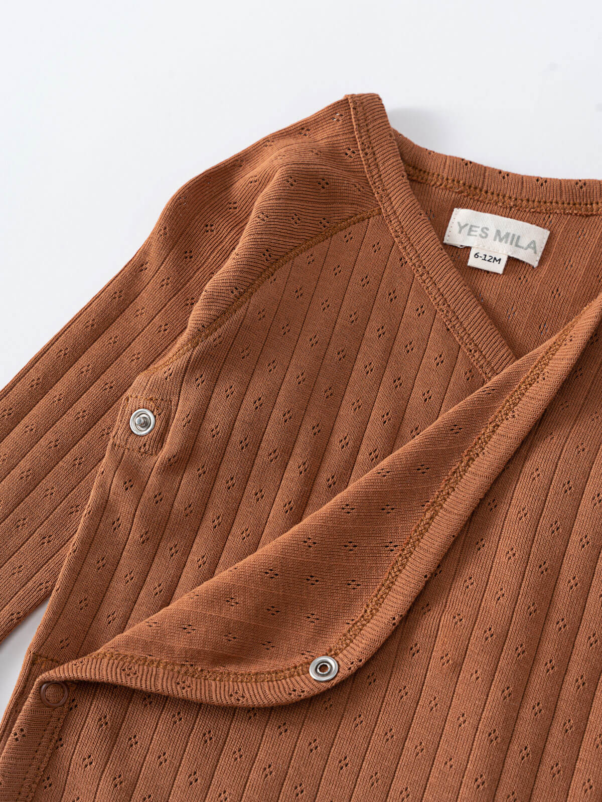 Close-up of a rust-colored ribbed bodysuit with snap closures Pointelle Crossover Bodysuit - Russet Baby boy