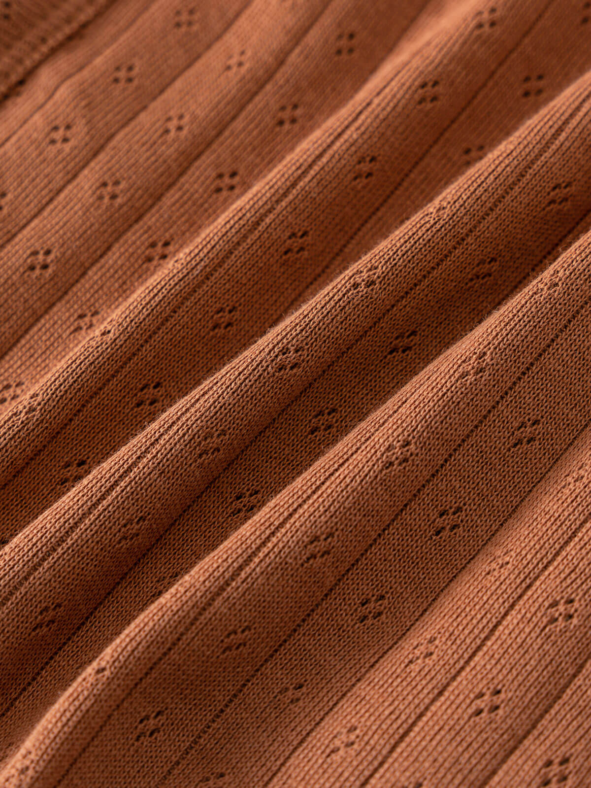 Close-up of rust-colored knitted fabric with eyelet detail and ribbed texture Pointelle Crossover Bodysuit - Russet Baby boy