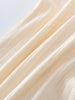 Close-up of beige fabric with a subtle pattern on a light gray background Pointelle Long Sleeve One Piece - Ecru Baby boy