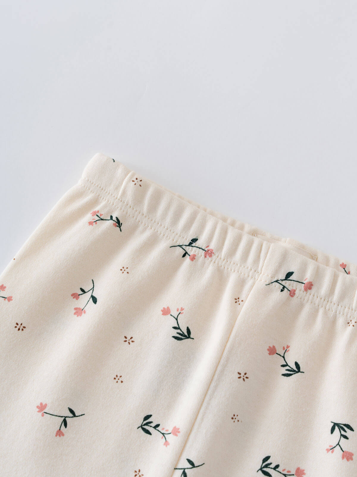 Close-up of cream-colored leggings with small pink floral embroidery pattern Printed Leggings - Wild Meadow Ecru Girls