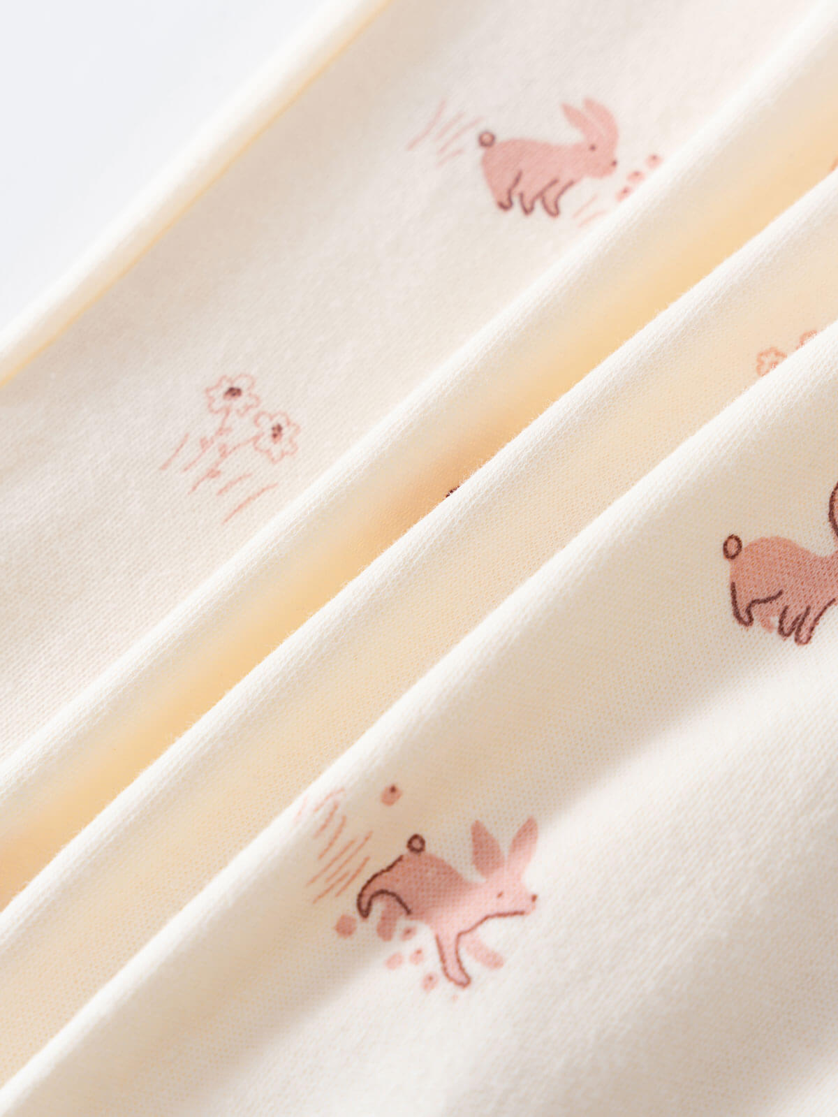 Close-up of cream fabric with pink rabbit and flower print Printed Long Sleeve One Piece - Meadow Friends Ecru Baby girl