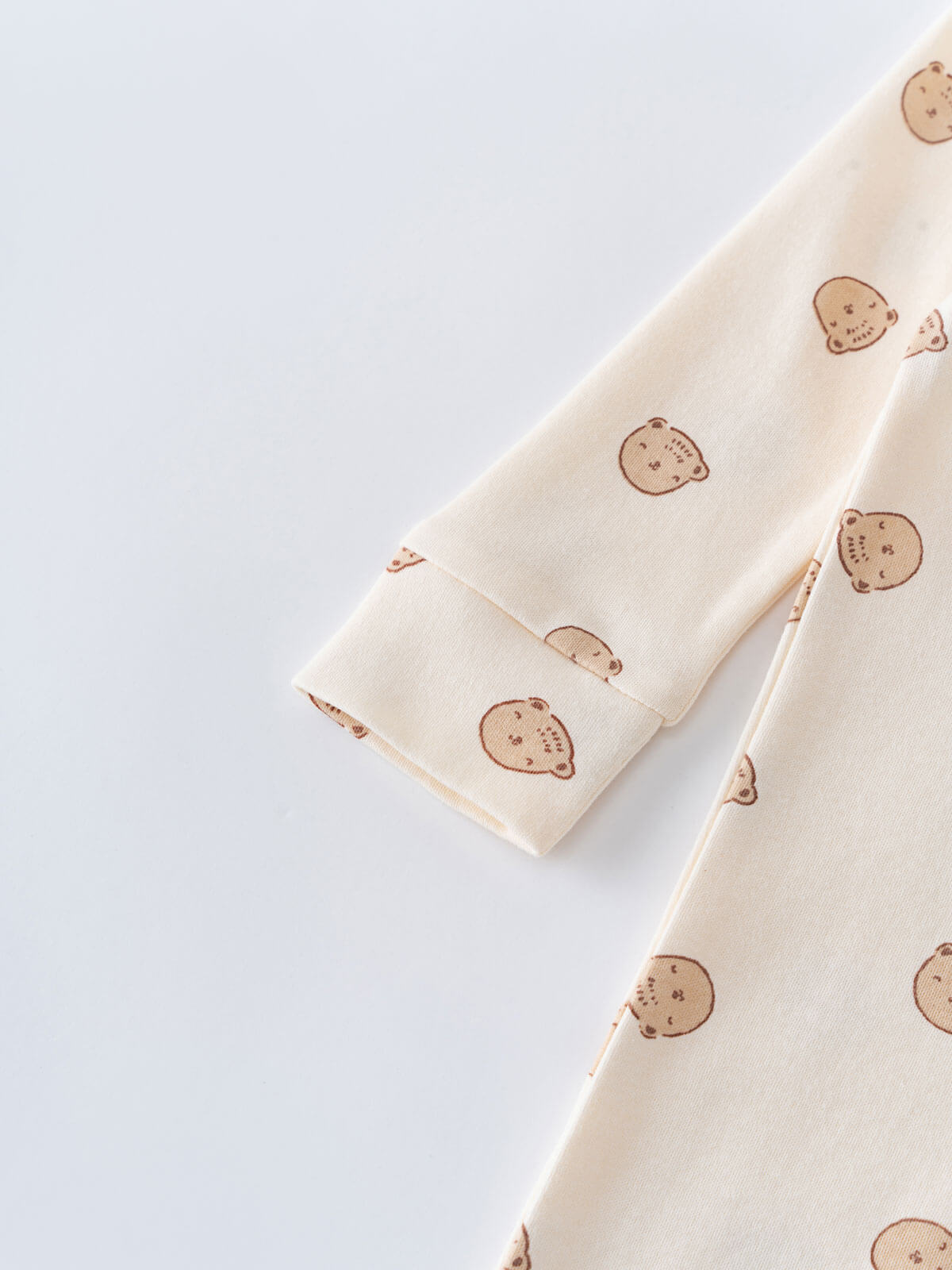 Cream fabric with brown bear face print folded on white surface Printed Long Sleeve One Piece - Cosy Bear Ecru Baby boy